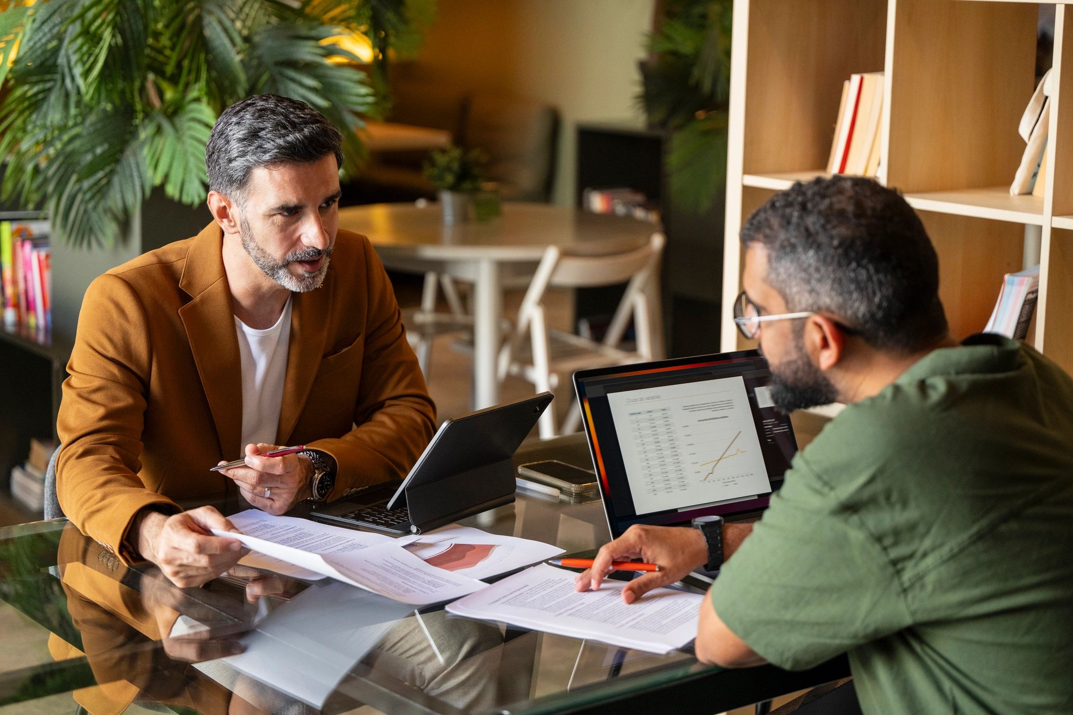 Landlord and agent meeting over paperwork and laptop